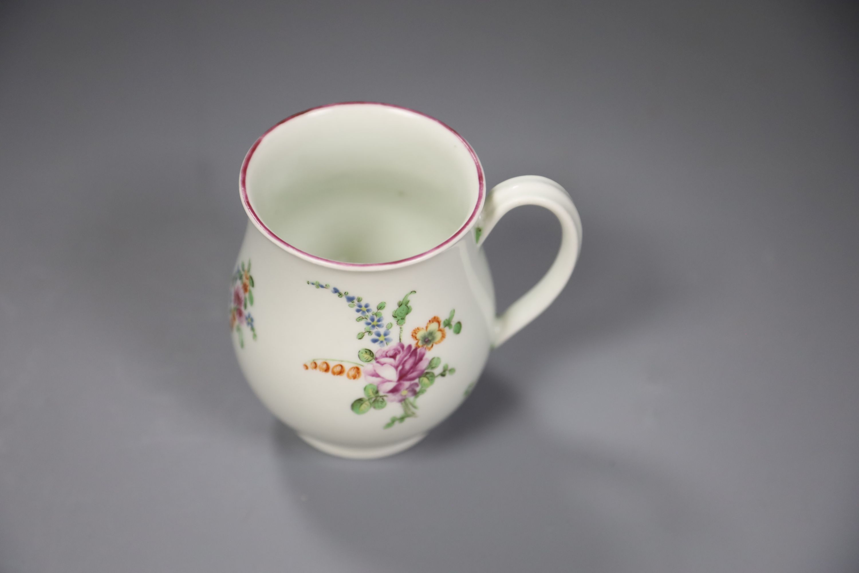 A Worcester bell shape mug painted with scattered coloured flowers, height 9cm